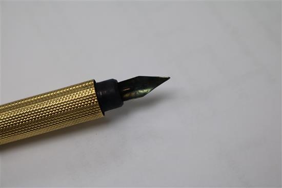 An Edwardian engine turned yellow metal fountain pen, with engraved inscription, 12.6cm.